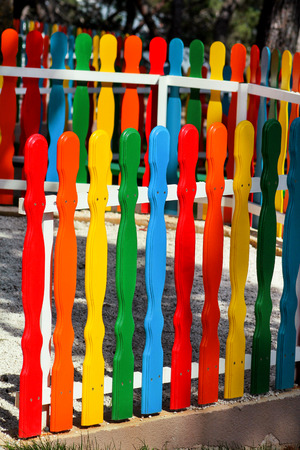 Colorful wooden decorative fence in the city park. Landscape architecture ideas, details. Colored wooden plank panel background texture. Art wooden background. Creative colorful wallpaper.の写真素材