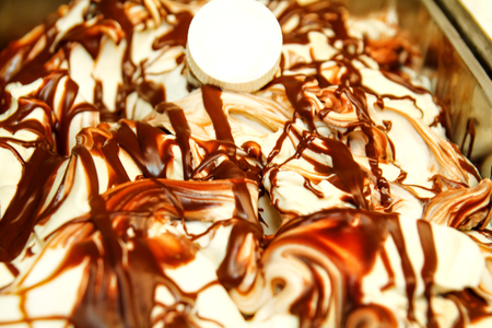 Closeup of Ice cream in the dishes in the fridge. Ice cream serving counter with many scoopable flavors. Fridge with ice cream. Ice cream shop. Pastry shop.の写真素材