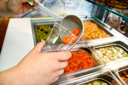 Set of fruit dessert for make a smoothie. Fresh fruits juices. The woman's hand making smoothie fruit, takes with ladle the fruit juice from the water and the fruit into a plastic cup. Healthy foods.の写真素材