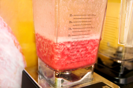 Fruit and vegetables smoothie in professional modern electric blender, closeup. Using blender for...