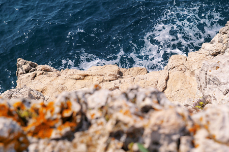 Rocks at seashore of Adriatic sea, Mediterranean, closeup. Aerial top view of sea waves hitting rocks on the beach.Stone, rocks, red algae and sea, shore and stones. Beautiful landscapes, seaside.の写真素材