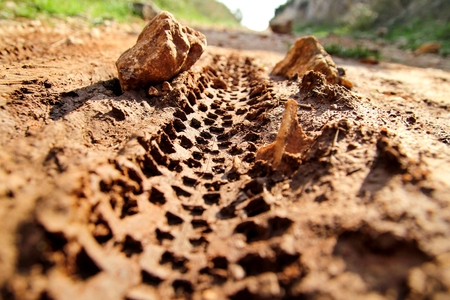 Bike tire tracks on muddy trail royalty. Tire tracks on wet muddy road, abstract background, texture material. Tyre track on dirt sand or mud, retro tone, grunge tone, drive on sand, off road track.の写真素材