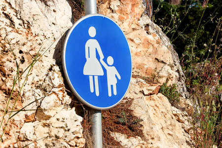 Sign or symbol for pedestrians. Warning road sign of blue sign baby take care when walk across the road symbol. Traffic sign with pedestrians in nature. Pedestrian sign. Forbidden and warning signs.の写真素材
