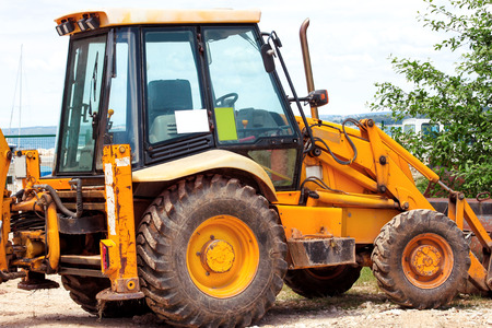 Yellow excavator, bulldozer machine and worker tractor. Road works. Road machinery at construction...