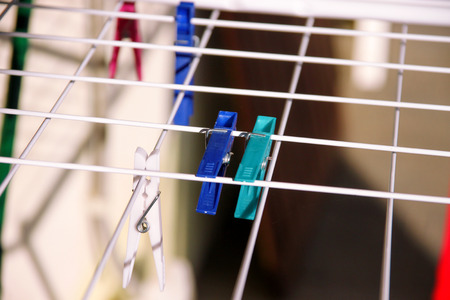 Cloth Clothespins on drying rack, selective focus. Colorful plastic clothespins on clothesline. A lot of multicolored wool cloth clamps attached the rope. Plastic color clothespin hanging on a wire.の写真素材