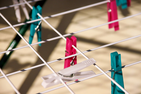 Cloth Clothespins on drying rack, selective focus. Colorful plastic clothespins on clothesline. A lot of multicolored wool cloth clamps attached the rope. Plastic color clothespin hanging on a wire.の写真素材