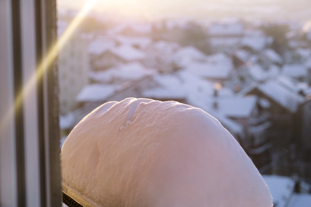 Window of home covered with big snow layer in winter, view from inside, close up.