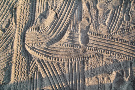 Tracks in sand. Part of prints and tracks of tire, foot, feet, sun sea slippers in beach sand.の写真素材