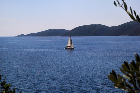 Lonely ship, sailboat at open sea. Calm sea allows best sailing in peaceful scene.の写真素材