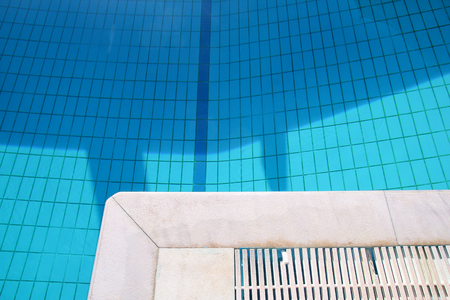 Blue ripped water in swimming pool in tropical resort with edge of pavement.の写真素材