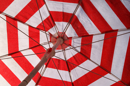 Part of red and white sun umbrella for sunbathing and protection of sun rays, closeup.の写真素材