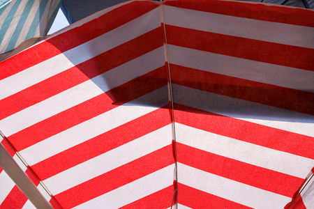 Part of red and white sun umbrella for sunbathing and protection of sun rays, closeupの写真素材