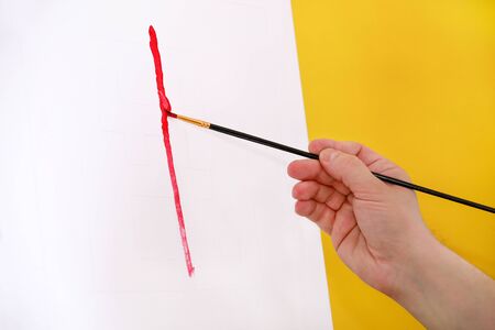 Male artist painter working in workshop with canvas on wood drawing board easel in art paint studio. Portrait of artist with paintbrush is painting on canvas with oil paints. Creativity concept.の写真素材