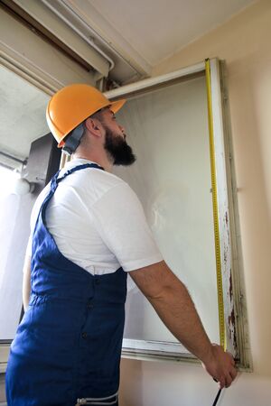 Construction worker and handyman is working on renovation of apartment.