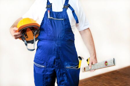 Construction worker at construction site with protective uniform, construction service tools and...