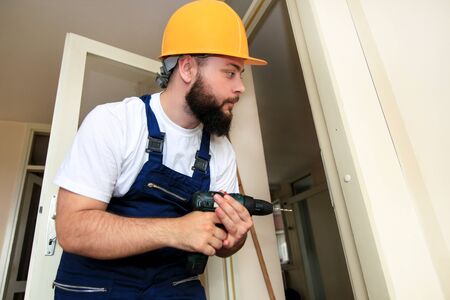 Construction worker and handyman works on renovation of apartment.