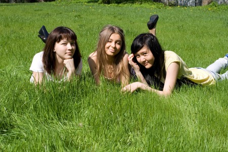 Three girls lying on grassの写真素材