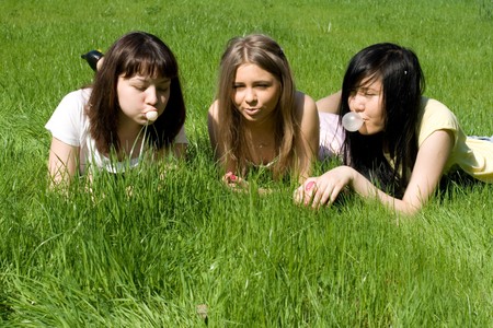 Three girls lying on grassの写真素材