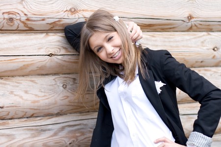 Girl standing in front of a wooden houseの写真素材