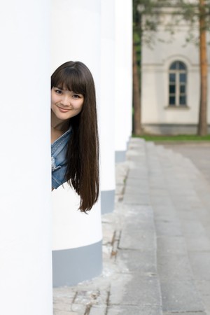 Girl hiding behind columnの写真素材