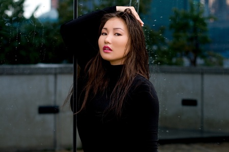 Sexy girl in black dress standing in front of a mirrorの写真素材