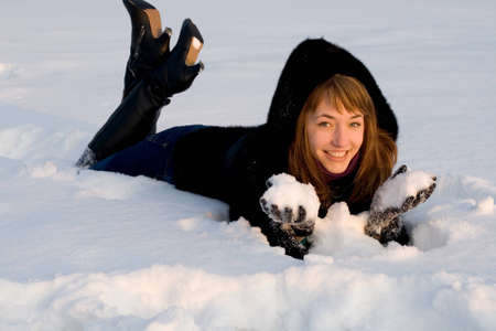 Portrait of a girl lying on snow fieldの写真素材
