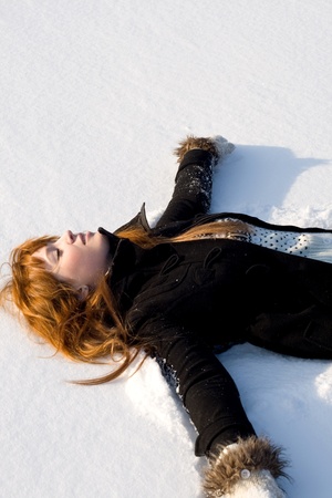 Portrait of a girl lying on snowの写真素材
