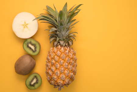 Fruits cut on a bright yellow background with a place for writingの写真素材