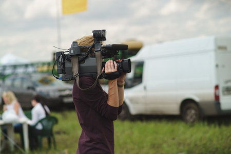 news TV operator shoots a report on the streetの写真素材