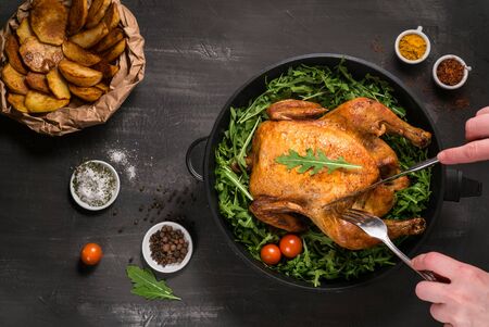 fried chicken or turkey cut by the hands of a person with green herbs in an iron dish の写真素材
