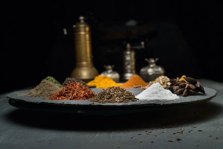 spices in variety on a dark background surrounded by oriental dishes space for textの写真素材