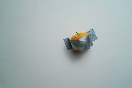 Art installation apple taped to a wallの写真素材