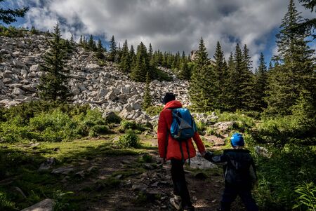 the girl holds the child by the hand go to the top of the mountainの写真素材