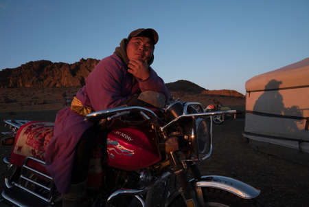Ulan Bator Mongolia, June 29,2019: a Mongol in national clothes on a motorcycle near a yurtのeditorial素材