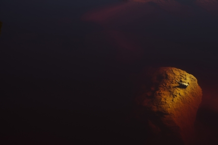 Submerged rocks and dry leaves in Rio Tintoの写真素材