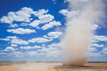 mini tornado whirlwind near the Outback Australian desert town of Marree, sandstorm, fluffy clouds and blue sky with copy space, South Australiaの写真素材