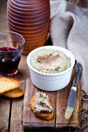 paste from a chicken liver, toasts, a glass with wine on a wooden table. style rusic. selective focusの写真素材