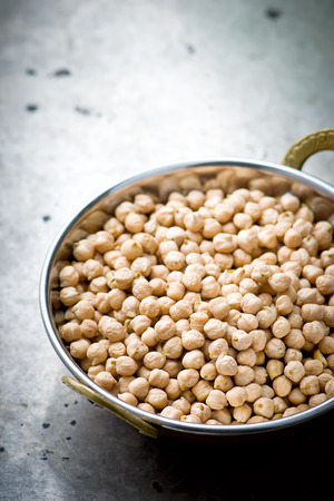 Dry chick-pea in the Indian copper bowl on a metal background. selective focusの写真素材