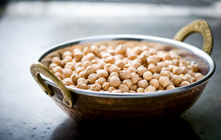 Dry chick-pea in the Indian copper bowl on a metal background. selective focusの写真素材
