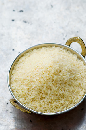 white rice in the Indian copper bowl on a metal background. selective focus.の写真素材