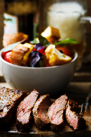 flank steak  with tomato salad and glass of beer. style vintage.  selective focusの写真素材