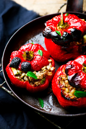 the sweet pepper stuffed with lamb and pearl barley in a vintage frying pan. style vintage. selective focusの写真素材