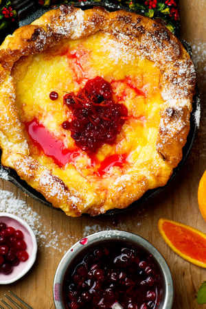 Dutch Baby with Cranberry Orange Compote. style rustic. selective focus