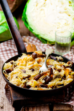 Cabbage solyanka with mushrooms in a vintage frying pan. style rustic. selective focusの写真素材