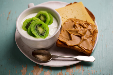 Natural yoghurt with kiwi and peanut butter toast. healthy breakfast..selective focusの写真素材
