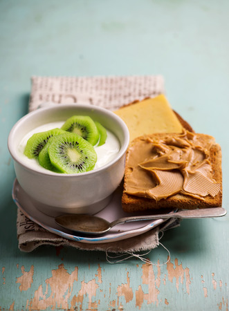 Natural yoghurt with kiwi and peanut butter toast. healthy breakfast..selective focusの写真素材