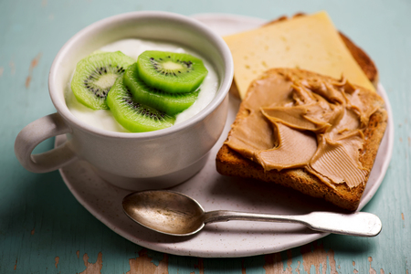 Natural yoghurt with kiwi and peanut butter toast. healthy breakfast..selective focusの写真素材