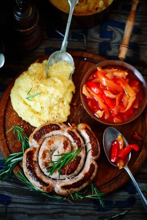 Fried sausages with polenta and vegetable sauce..style rustic.selective focusの写真素材