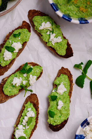 Green pea dip with crostini and feta. top view..selective focusの写真素材