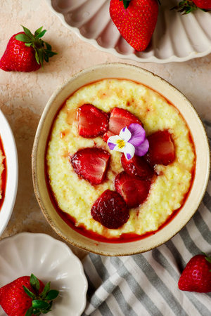 Creamy millet porridge with baked strawberries in to the bowl.selective focus. top veiwの写真素材